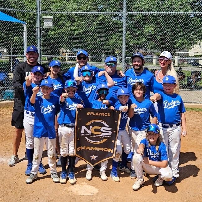 Young Brothers Academy travel team holding an NCS Champion banner, showing their rings