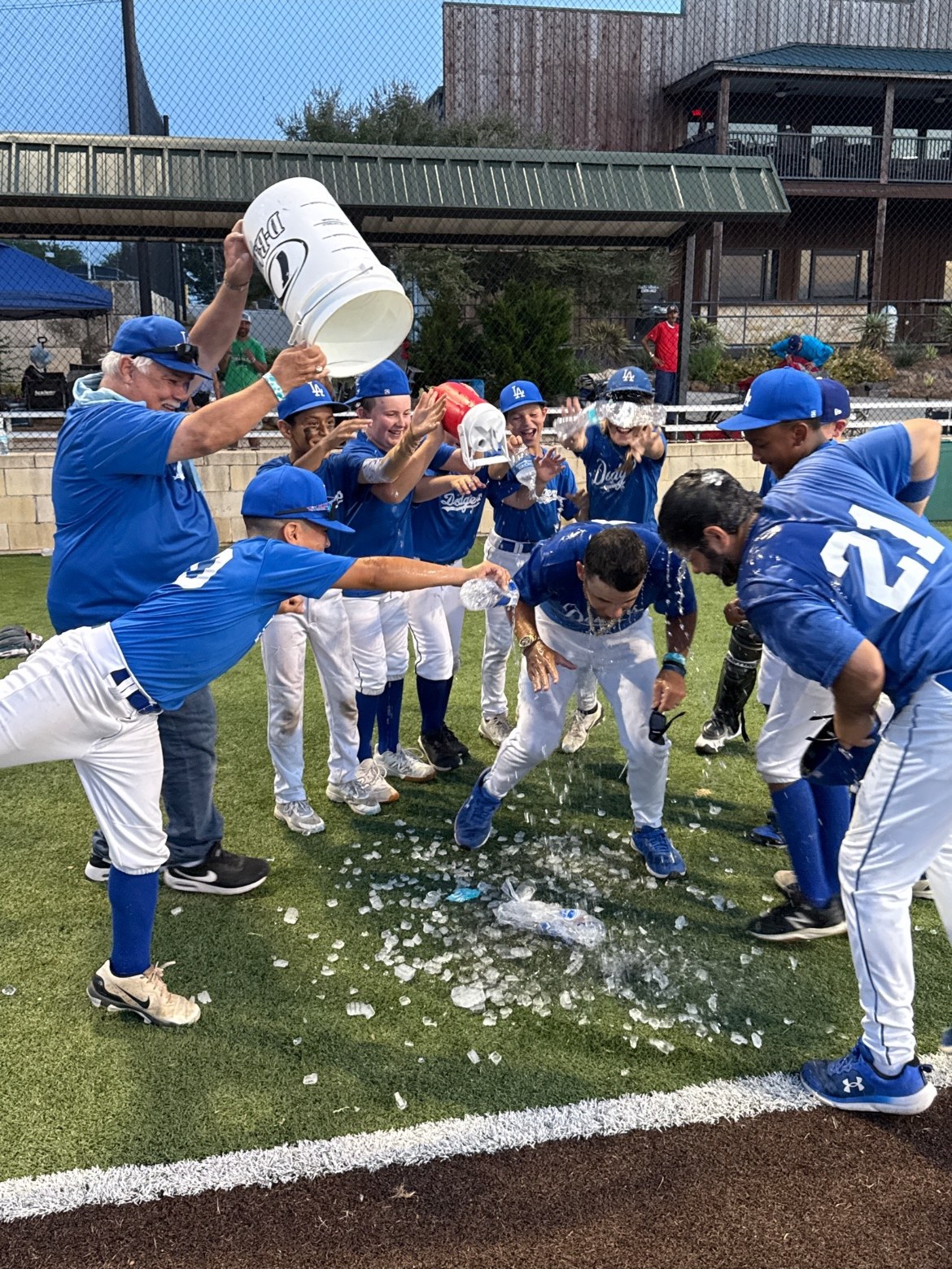 Dodgers players dumping a bucket of ice water over their coaches after a win