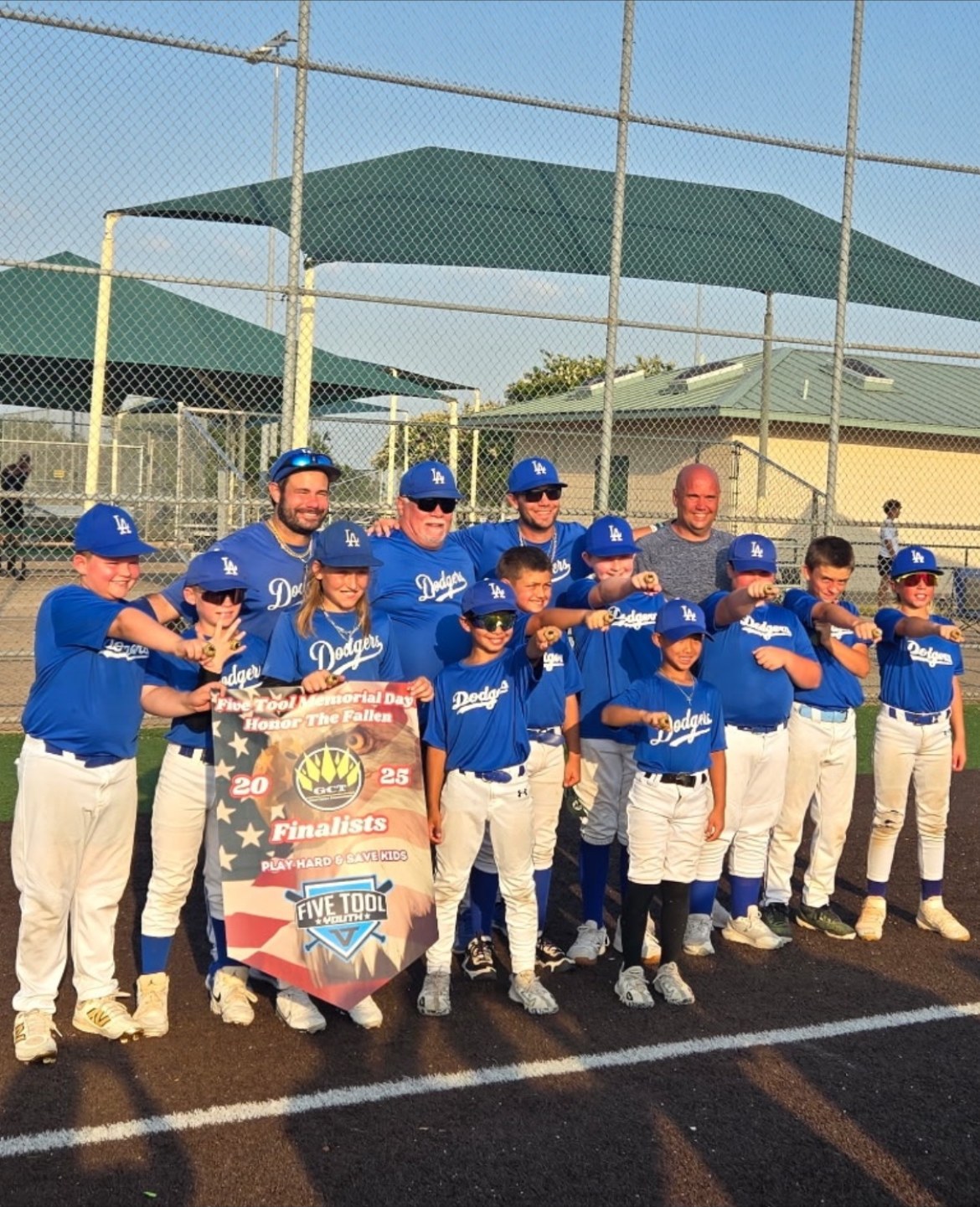 Matt Young and his Dodgers youth team holding a tournament Finalists banner and showing their rings