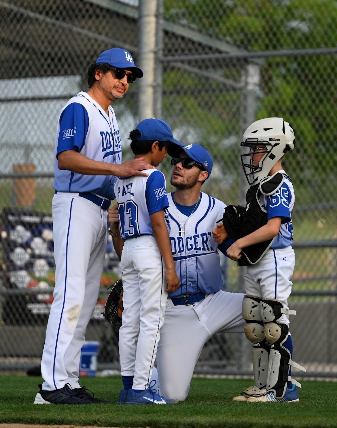 Matt Young kneeling on the mound to talk with his pitcher and catcher