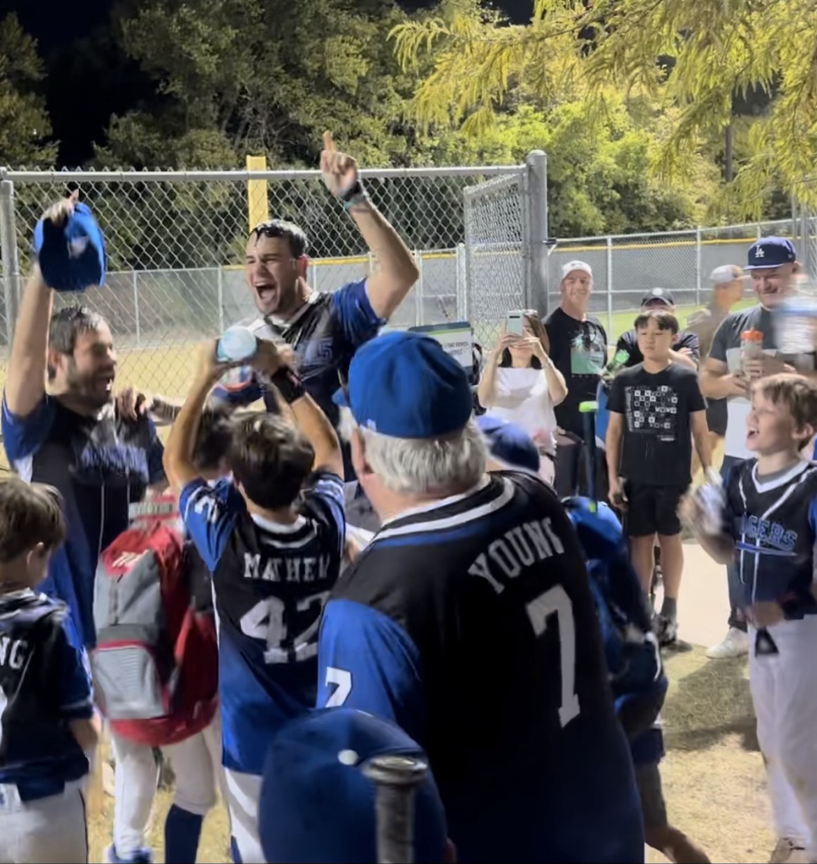 Matt Young cheering with his players and fellow coaches after a game