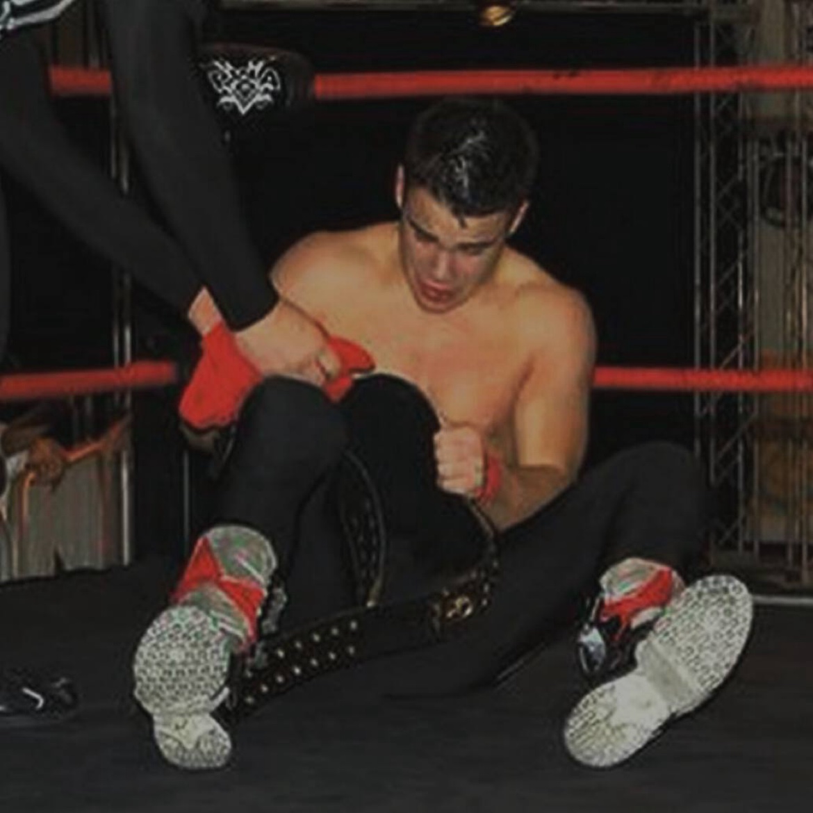Sitting in the ring holding the red boots